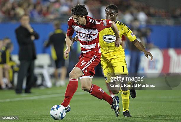 Defender Heath Pearce of FC Dallas dribbles the ball past Emmanuel Ekpo of the Columbus Crew at Pizza Hut Park on April 10, 2010 in Frisco, Texas.