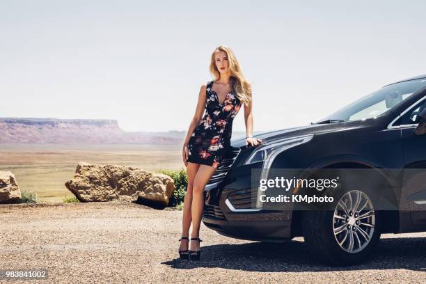 blonde model with black car near cliffs kmphoto - kmphoto stock pictures, royalty-free photos & images