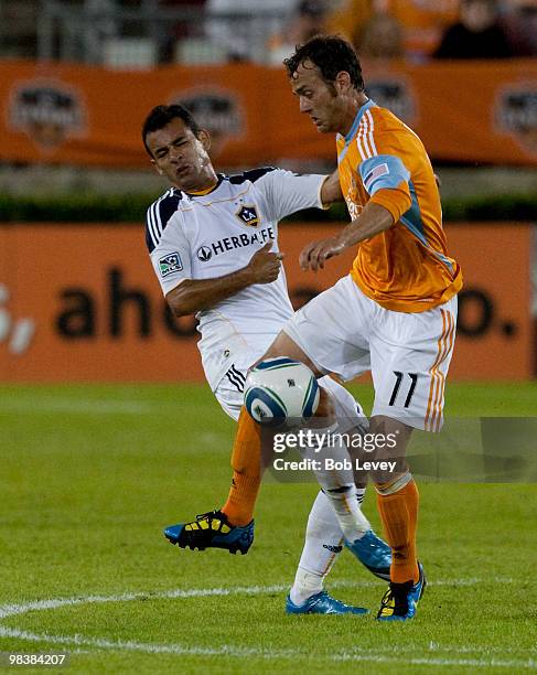 Brad Davis of the Houston Dynamo knocks Juninho of the Los Angeles Galaxy off the ball on April 10, 2010 in Houston, Texas.