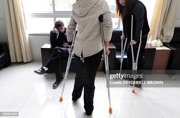 Health-China-lifestyle,FEATURE" by Pascal Trouillaud Young women walk on crutches after having been operated on by orthopedic surgeon Bai Helong, who...