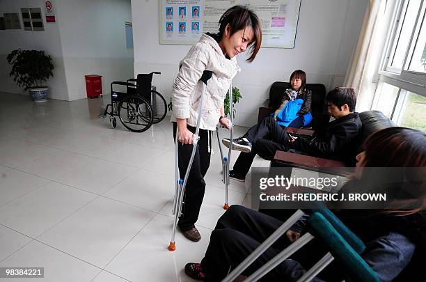 Health-China-lifestyle,FEATURE" by Pascal Trouillaud A woman on crutches chats with another patient, seated, comparing experiences after having been...