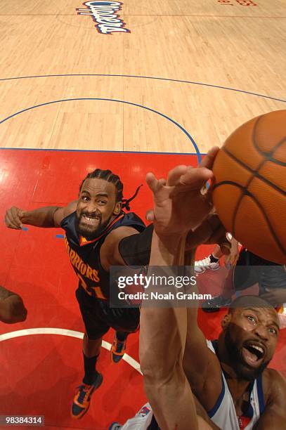 Ronny Turiaf of the Golden State Warriors and Baron Davis of the Los Angeles Clippers reach for a rebound during their game at Staples Center on...