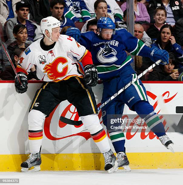 Jay Bouwmeester of the Calgary Flames sidesteps a check by Jannik Hansen of the Vancouver Canucks during their game at General Motors Place on April...