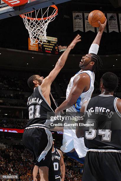 Nene dunks over Tim Duncan during the game against the San Antonio Spurs on April 10, 2010 at the Pepsi Center in Denver, Colorado. NOTE TO USER:...