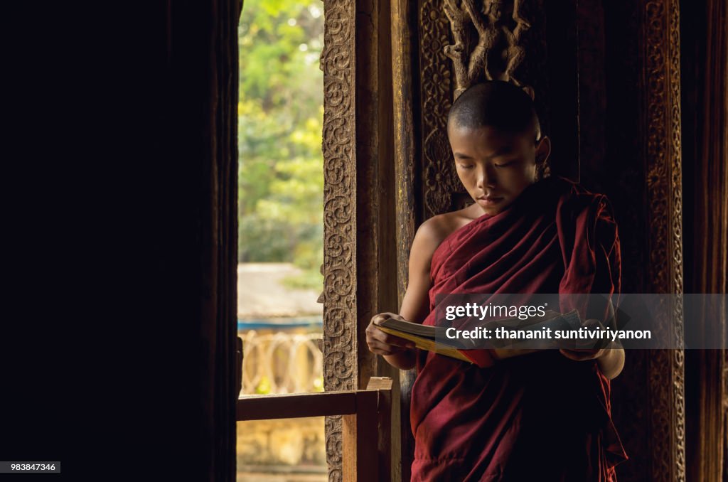 Closeup Buddhist novice reading at Shwenandaw pagoda, mandalay,
