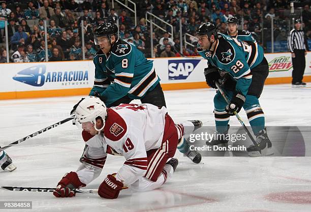 Shane Doan of the Phoenix Coyotes falls to the ice against Joe Pavelski and Ryane Clowe of the San Jose Sharks during an NHL game on April 10, 2010...