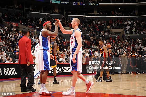Bobby Brown and Steve Blake of the Los Angeles Clippers slap hands following their team's victory over the Golden State Warriors at Staples Center on...