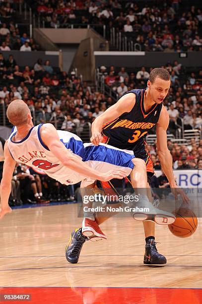 Stephen Curry of the Golden State Warriors knocks down Steve Blake of the Los Angeles Clippers on his way to the basket at Staples Center on April...