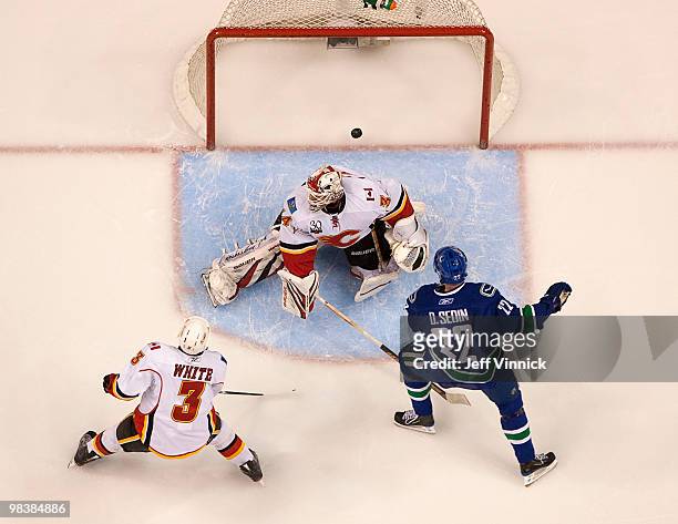 Ian White of the Calgary Flames looks on as Daniel Sedin of the Vancouver Canucks scores his hat trick goal on Miikka Kiprusoff of the Calgary Flames...