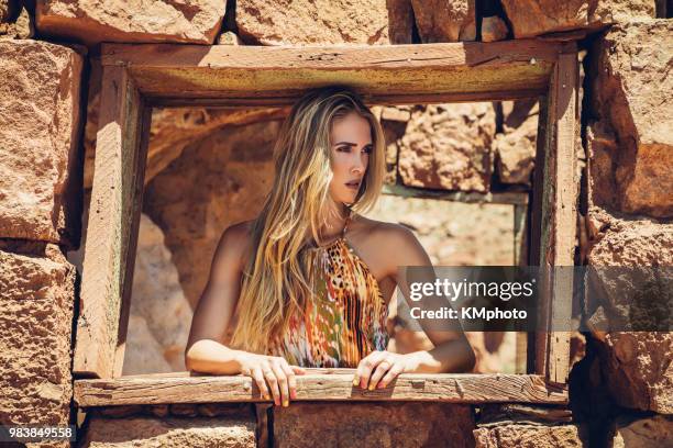 blonde girl in wooden frame in stone wall kmphoto - kmphoto stock pictures, royalty-free photos & images