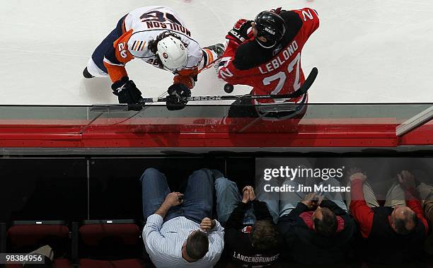 Fans look on as Pierre-Luc Letourneau-Leblond of the New Jersey Devils collides with Matt Moulson of the New York Islanders at the Prudential Center...