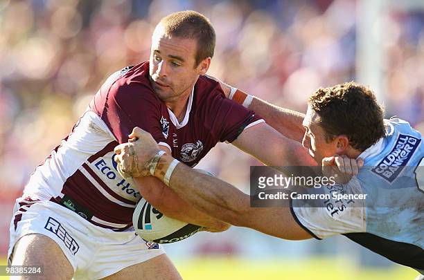 Michael Robertson of the Sea Eagles is tackled by Ben Pomeroy of the Sharks during the round five NRL match between the Manly Sea Eagles and the...