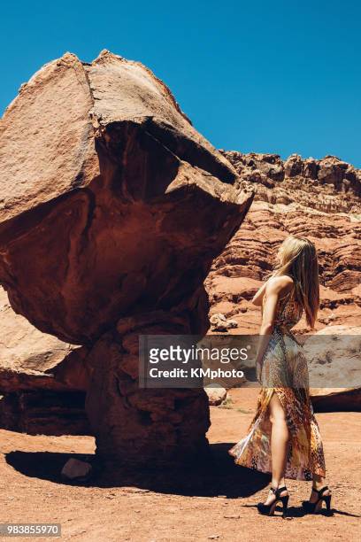 blonde girl looking up to pedestal rock kmphoto - kmphoto stock pictures, royalty-free photos & images