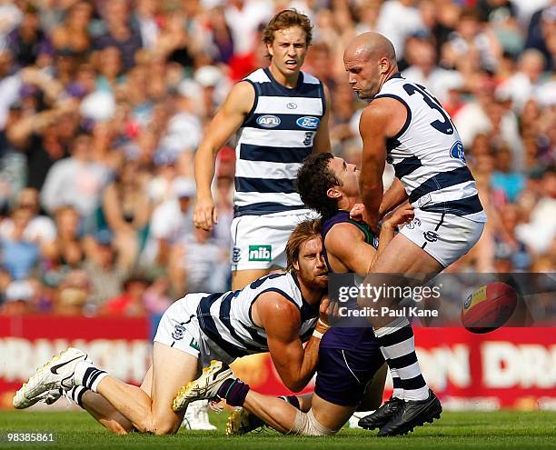 Hayden Ballantyne of the Dockers gets tackled by Tom Lonergan and Paul Chapman of the Cats during the round three AFL match between Fremantle Dockers...