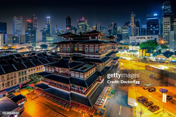 buddha tooth relic temple with skyscraper buildings of singapore city - zuid china stockfoto's en -beelden