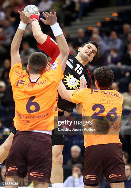 Michal Jurecki of Luebbecke fights for the ball with Drago Vukovic and Adrian Pfahl of Gummersbach during the DHB Cup third place match between VfL...