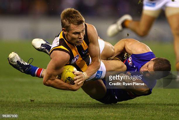 Sam Mitchell of the Hawks is tackled by Matthew Boyd of the Bulldogs during the round three AFL match between the Western Bulldogs and the Hawthorn...
