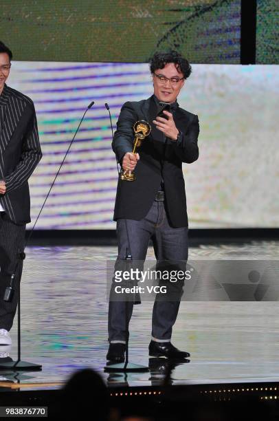 Singer Eason Chan uses cellphone take a picture of his trophy during the 29th Golden Melody Awards ceremony on June 23, 2018 in Taipei, Taiwan of...