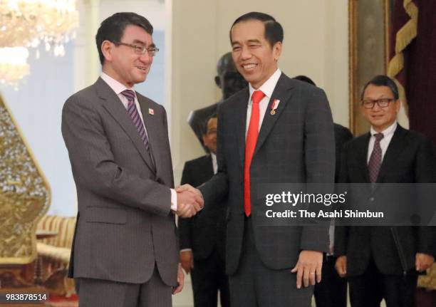 Japanese Foreign Minister Taro Kono and Indonesia President Joko Widodo shake hands prior to their meeting at the presidential office on June 25,...