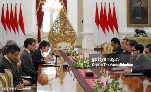 Japanese Foreign Minister Taro Kono and Indonesia President Joko Widodo talk during their meeting at the presidential office on June 25, 2018 in...