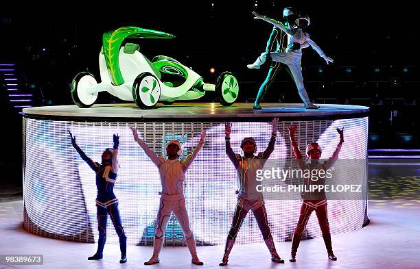 Performers dance as a concept car by SAIC is displayed during a media preview of the GM and SAIC pavilion of the World Expo 2010 in Shanghai on April...