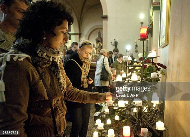 People light candles during a church service for Polish president Lech Kaczynski in Berlin on April 11, 2010 the day after a plane carrying Polish...