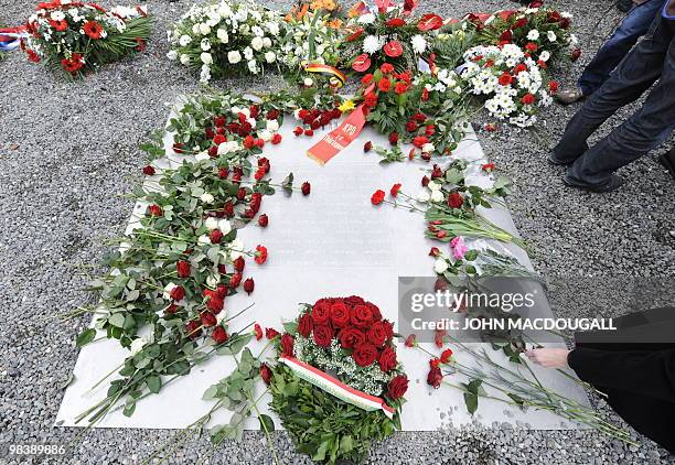 Woman lays a flower on a memorial plaque during celebrations marking the 65th anniversary of the liberation of the Buchenwald Nazi concentration camp...