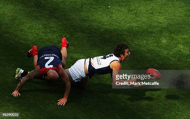 Kurt Tippett of the Crows handballs to a teammate as he is challenged by Nathan Jones of the Demons during the round three AFL match between the...