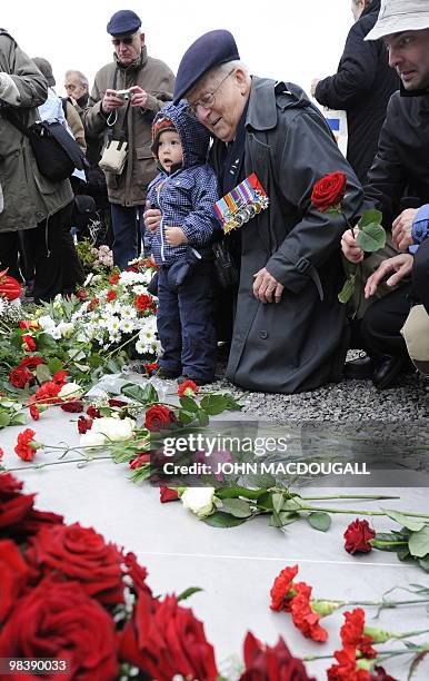 Canadian airman Ed Carter-Edwards tries to get his great grandson to lay a flower on a memorial plaque during celebrations marking the 65th...