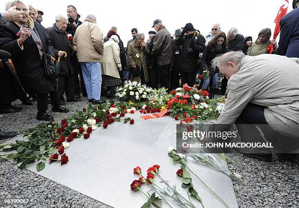 Man touches a memorial plaque during celebrations marking the 65th anniversary of the liberation of the Buchenwald Nazi concentration camp outside...