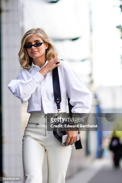 Xenia Adonts wears a white shirt, white pants, a Dior bag, sunglasses, outside 1017 ALYX 9SM, during Paris Fashion Week - Menswear Spring-Summer...