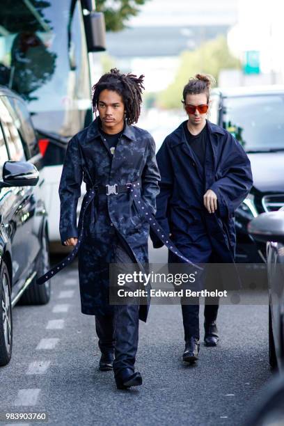 Luka Sabbat wears a dark camo print trench coat, a belt, outside 1017 ALYX 9SM, during Paris Fashion Week - Menswear Spring-Summer 2019, on June 24,...