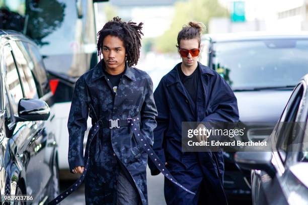 Luka Sabbat wears a dark camo print trench coat, a belt, outside 1017 ALYX 9SM, during Paris Fashion Week - Menswear Spring-Summer 2019, on June 24,...