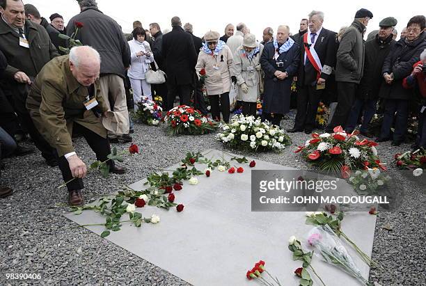 Man lays a flower on a memorial plaque during celebrations marking the 65th anniversary of the liberation of the Buchenwald Nazi concentration camp...