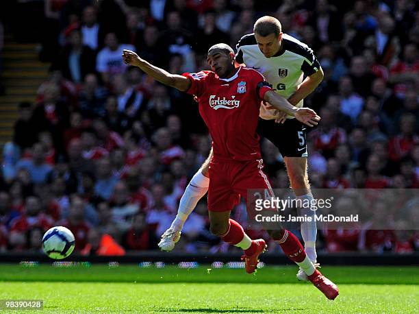 Brede Hangeland of Fulham competes for the ball with David Ngog of Liverpool during the Barclays Premier League match between Liverpool and Fulham at...