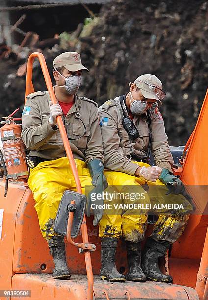 Two rescue workers sit on a crane used to dig in the mud left by a landslide at Vicoso Jardim Bumba shantytown in Niteroi, 25 km from Rio de Janiero,...