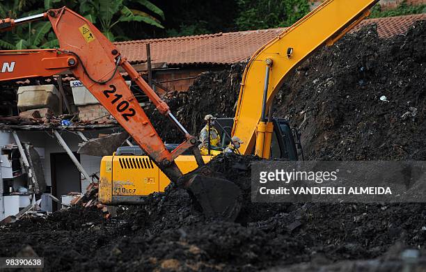 Rescue workers with heavy machinery dig in the mud left by a landslide at Vicoso Jardim Bumba shantytown in Niteroi, 25 km from Rio de Janiero,...