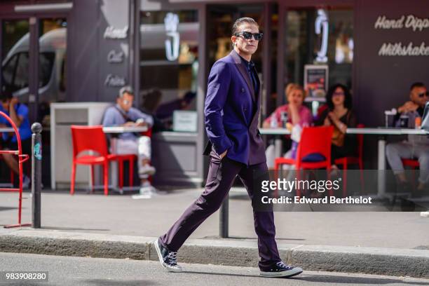 Carlo Sestini wears a purple blazer jacket, sunglasses, black pants, sneakers shoes, outside Paul Smith, during Paris Fashion Week - Menswear...