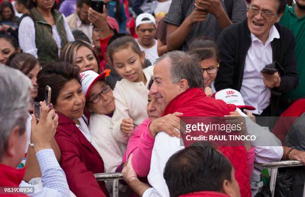 Mexico's presidential candidate for Todos por Mexico -a coalition of the PRI, PVEM and Nueva Alianza parties- Jose Antonio Meade hugs a supporter...