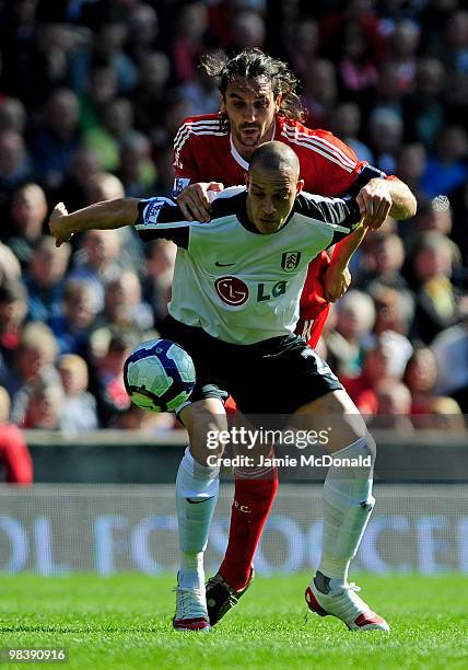 Sotiros Kyrgiakos of Liverpool tangles with Bobby Zamora of Fulham during the Barclays Premier League match between Liverpool and Fulham at Anfield...