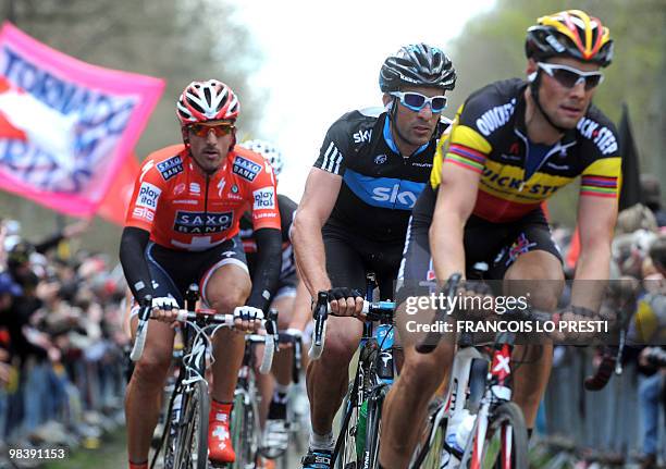 Belgian Tom Boonen , Spanish Juan Antonio Flecha and Swiss Fabian Cancellara leave the cobblestone section "La tranchée d'Aramberg" during the 108th...
