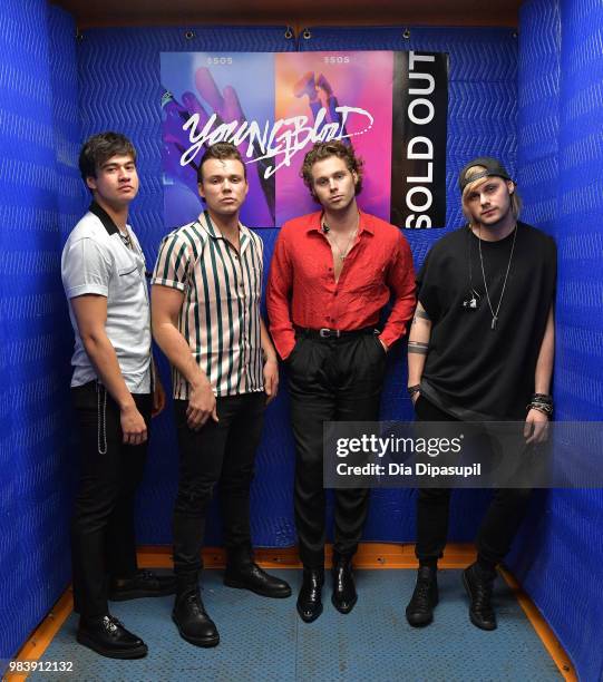 Calum Hood, Ashton Irwin, Luke Hemmings, and Michael Clifford of 5 Seconds of Summer pose backstage before performing at the Tumblr IRL with 5...