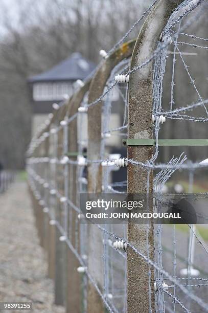 View of a barbed wire fence and a watch tower at the Buchenwald Nazi concentration camp during celebrations marking the 65th anniversary of the...