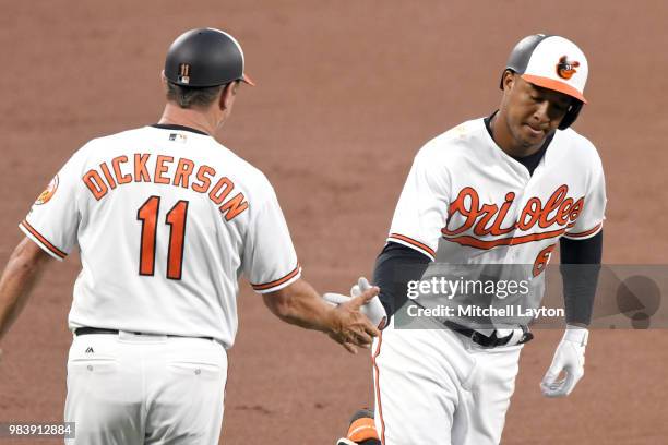 Jonathan Schoop of the Baltimore Orioles celebrates a solo home run in the fifth inning with third base coach Bobby Dickerson during a baseball game...