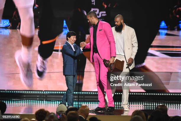 Actor Ken Jeong and Tyson Chandler of the Phoenix Suns present Rudy Gobert of the Utah Jazz with the award for Defensive Player of the Year during...