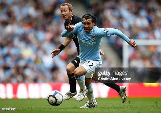Carlos Tevez of Manchester City is challenged by Lee Bowyer of Birmingham City during the Barclays Premier League match between Manchester City and...