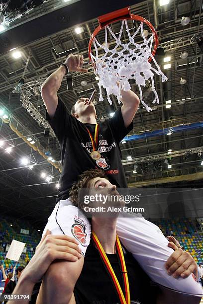 Tibor Pleiss of Brose Baskets lifts up his team mate Karsten Tadda as he cuts off the net after winning the Beko BBL Top Four basketball tournament...