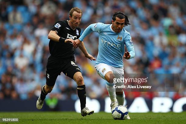 Carlos Tevez of Manchester City is challenged by Lee Bowyer of Birmingham City during the Barclays Premier League match between Manchester City and...
