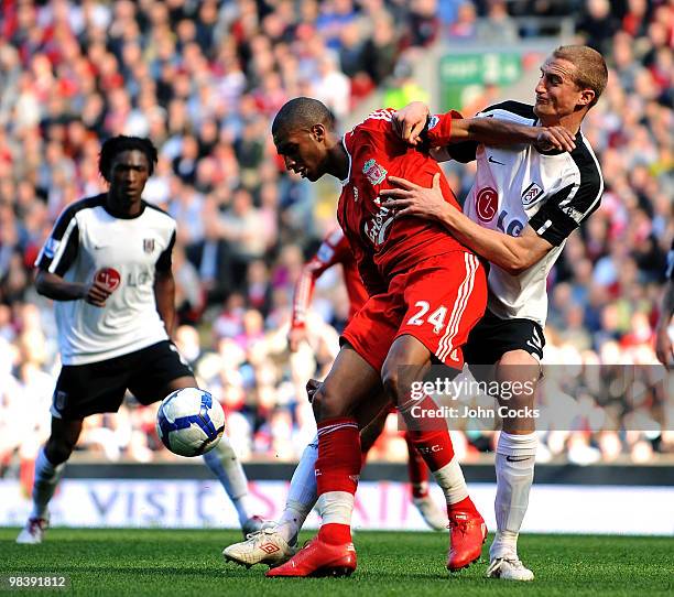David Ngog of Liverpool competes with Brede Hangeland of Fulham during the Barclays Pemier League match between Liverpool Fulham at Anfield on April...