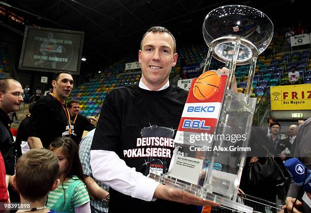 Head coach Chris Fleming of Brose Baskets Bamberg poses with the trophy after winning the Beko BBL Top Four basketball tournament against Deutsche...